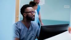 A nurse registering a patient on a desktop computer