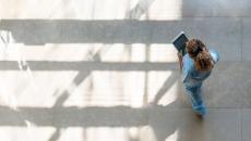 High-angle shot of a nurse using a digital tablet while walking