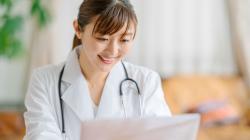 Healthcare worker smiling at laptop screen