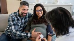 Pregnant couple talking to doctor