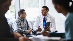 Doctor showing tablet to patient