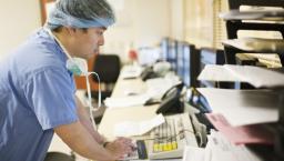 Doctor in scrubs using computer