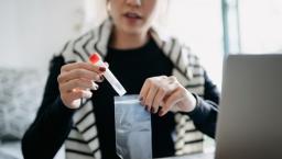 A person placing a medical test tube inside a plastic bag