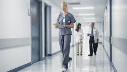 A nurse checking a patient record on a digital tablet