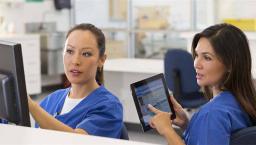 Nurses talking and pointing at device screens