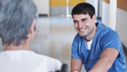 A nurse talking to a senior patient in a wheelchair