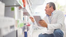 A pharmacist holding a digital tablet doing an inventory 