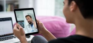 A person using a tablet for a video call with a doctor.