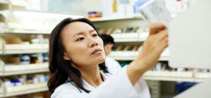 A pharmacist arranging medicines on a rack