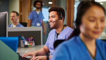 healthcare worker with headset using a computer