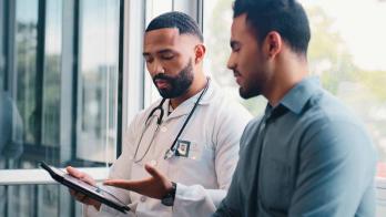 Doctor showing tablet to patient