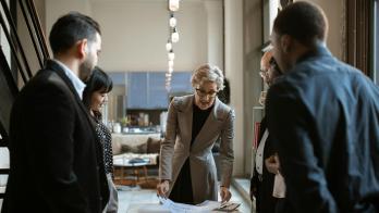 Developers around a table with documents discussing product life cycles