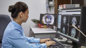 Woman reviews medical imaging on a desktop computer