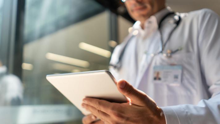 Physician using tablet with AI clinical decision support