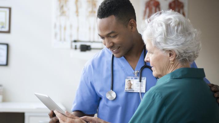 A nurse and a senior patient using a digital tablet