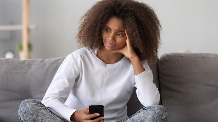 Upset woman holding smartphone