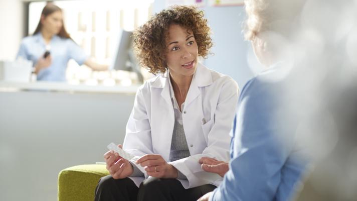 Pharmacist assisting senior customer.