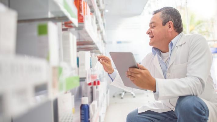 A pharmacist doing an inventory using a digital tablet